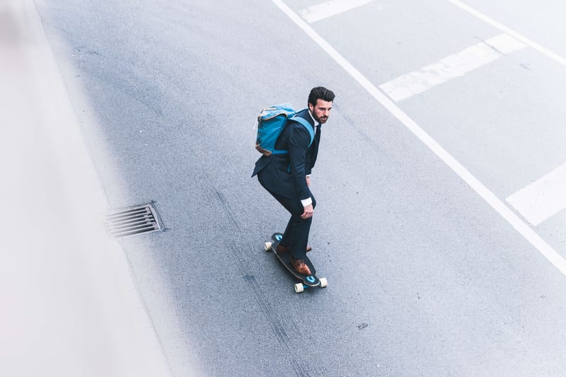 Mann mit Anzug auf Skateboard