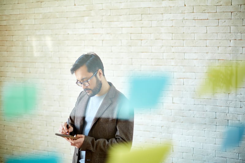 Mann in Büro mit Post-Its an der Wand