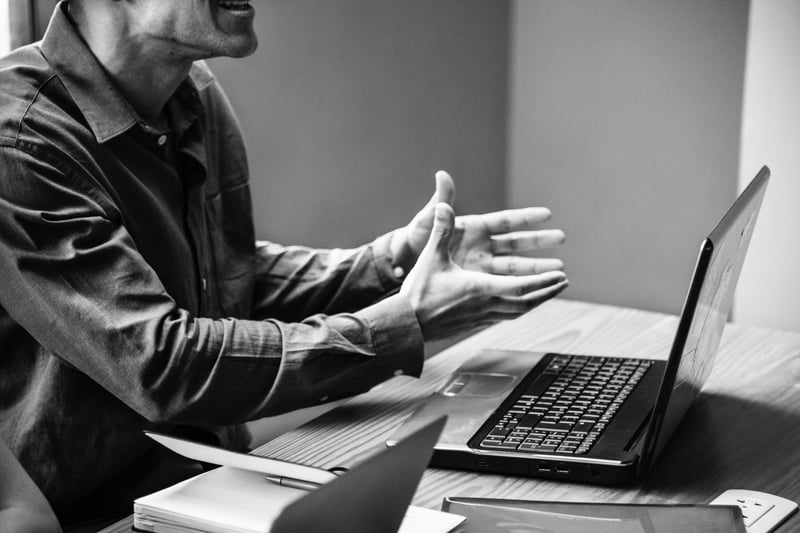 Mann vor Laptop in Erklärungsnot