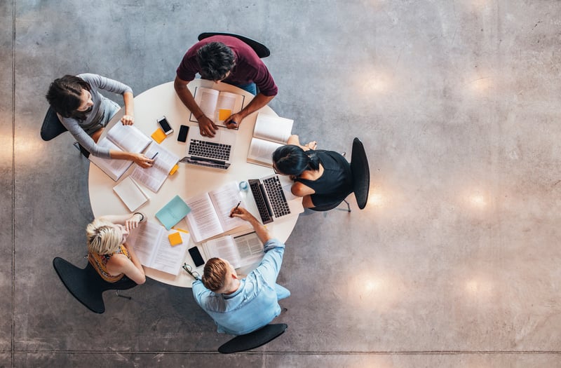 Vogelperspektive eines Meetings mit 5 Personen