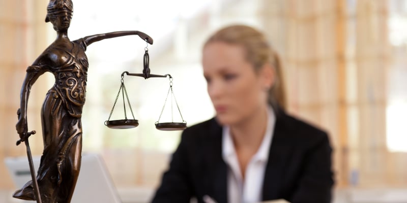 Geschäftsfrau mit Justizia Figur