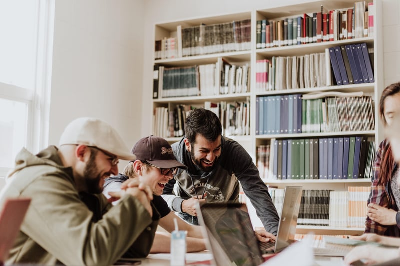 3 Personen lachend am Arbeitsplatz