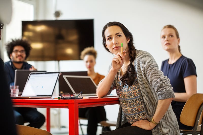 Eine Frau erklärt in einem Meeting etwas