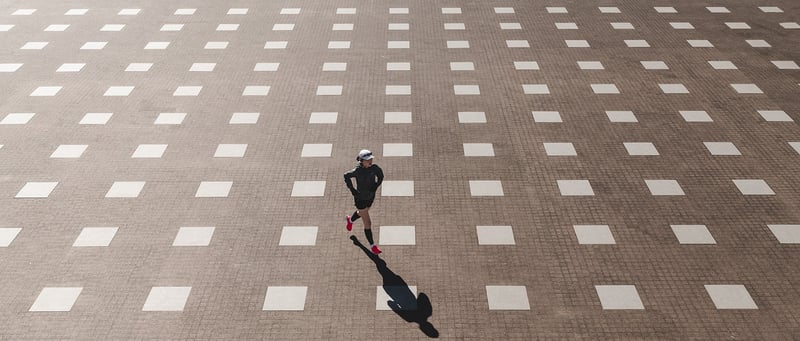Joggerin überquert gepflasterten Platz