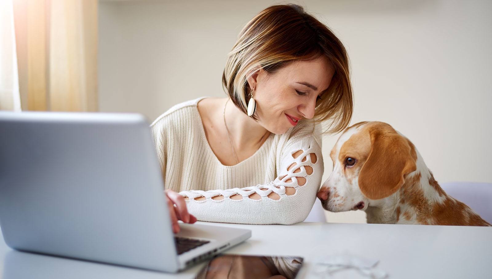 Frau mit Hund vor Laptop