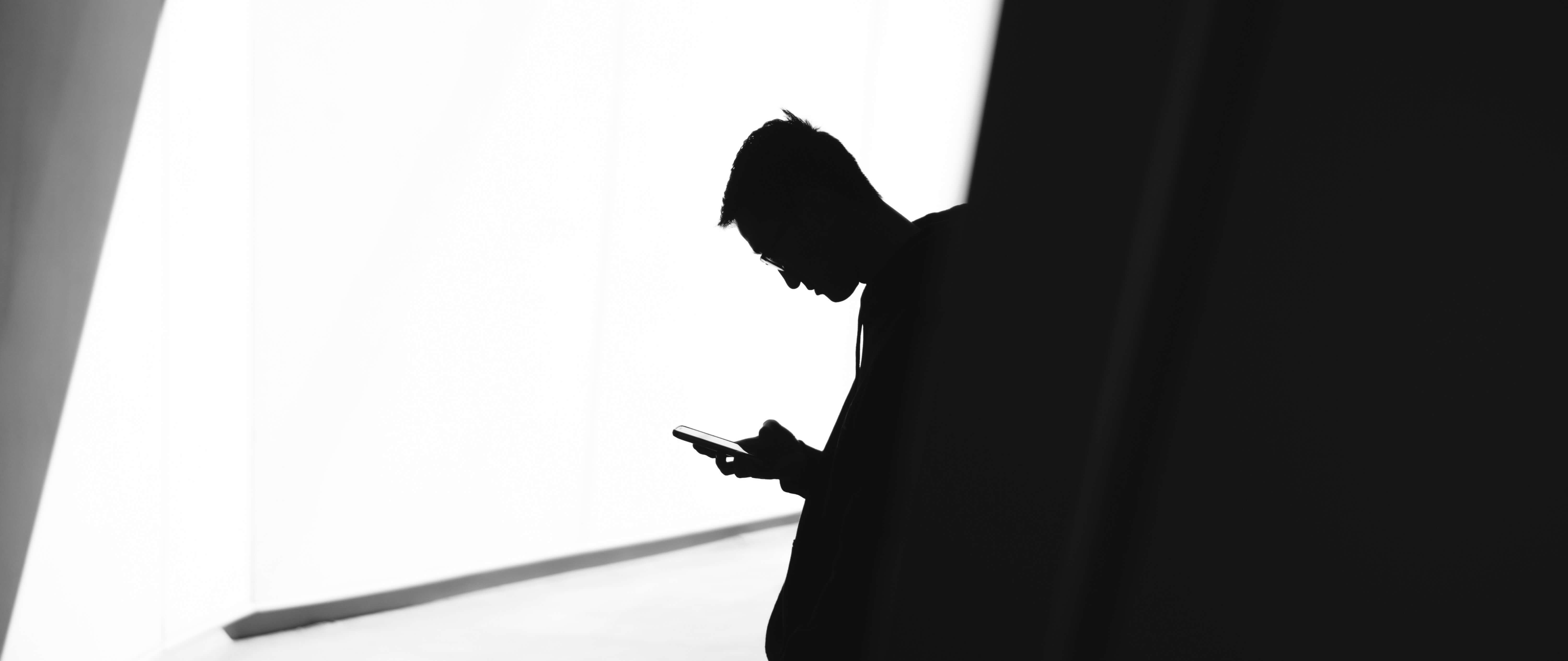 Silhouette im Licht von Person am Smartphone