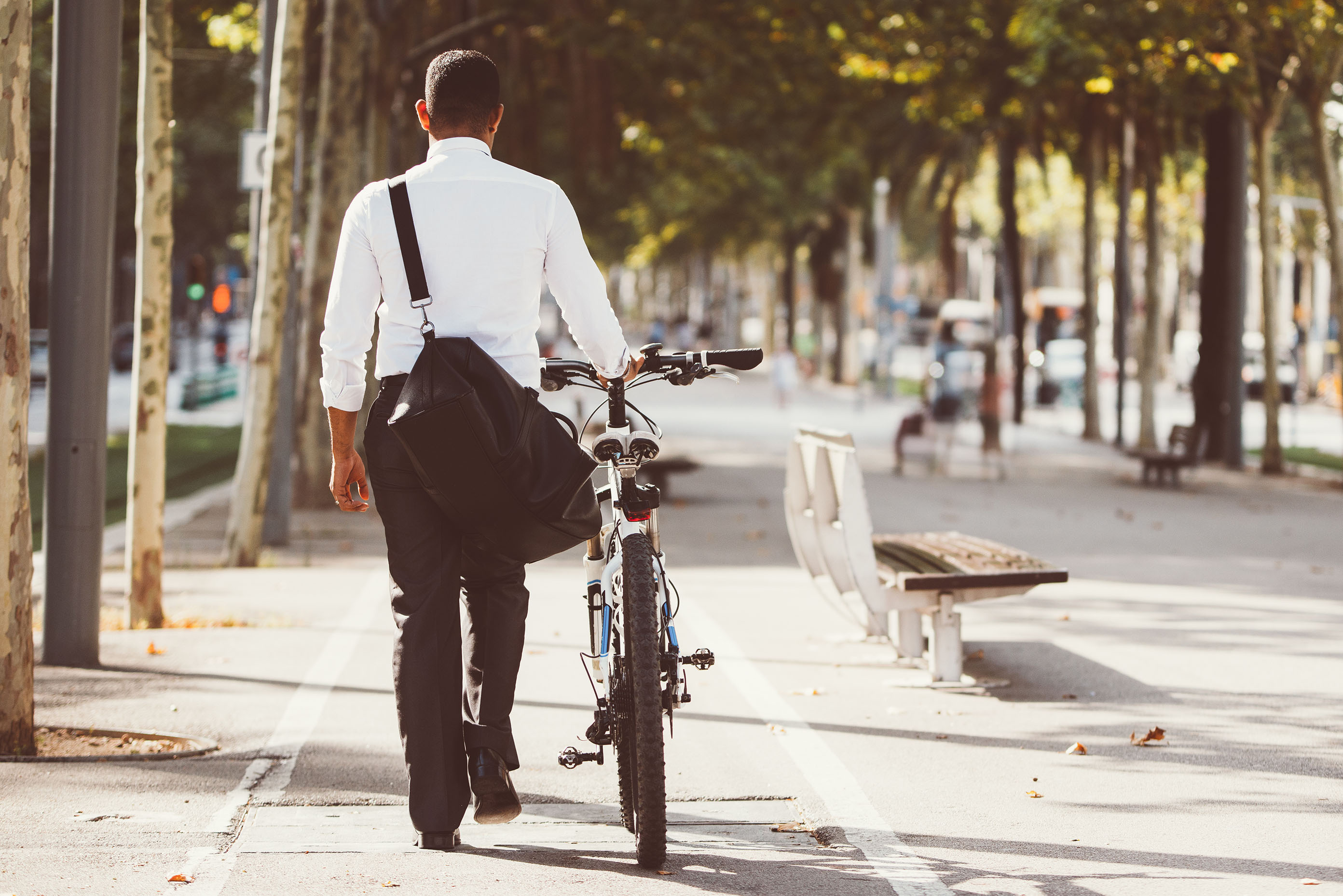 Mann schiebt Fahrrad über Fußgängerweg