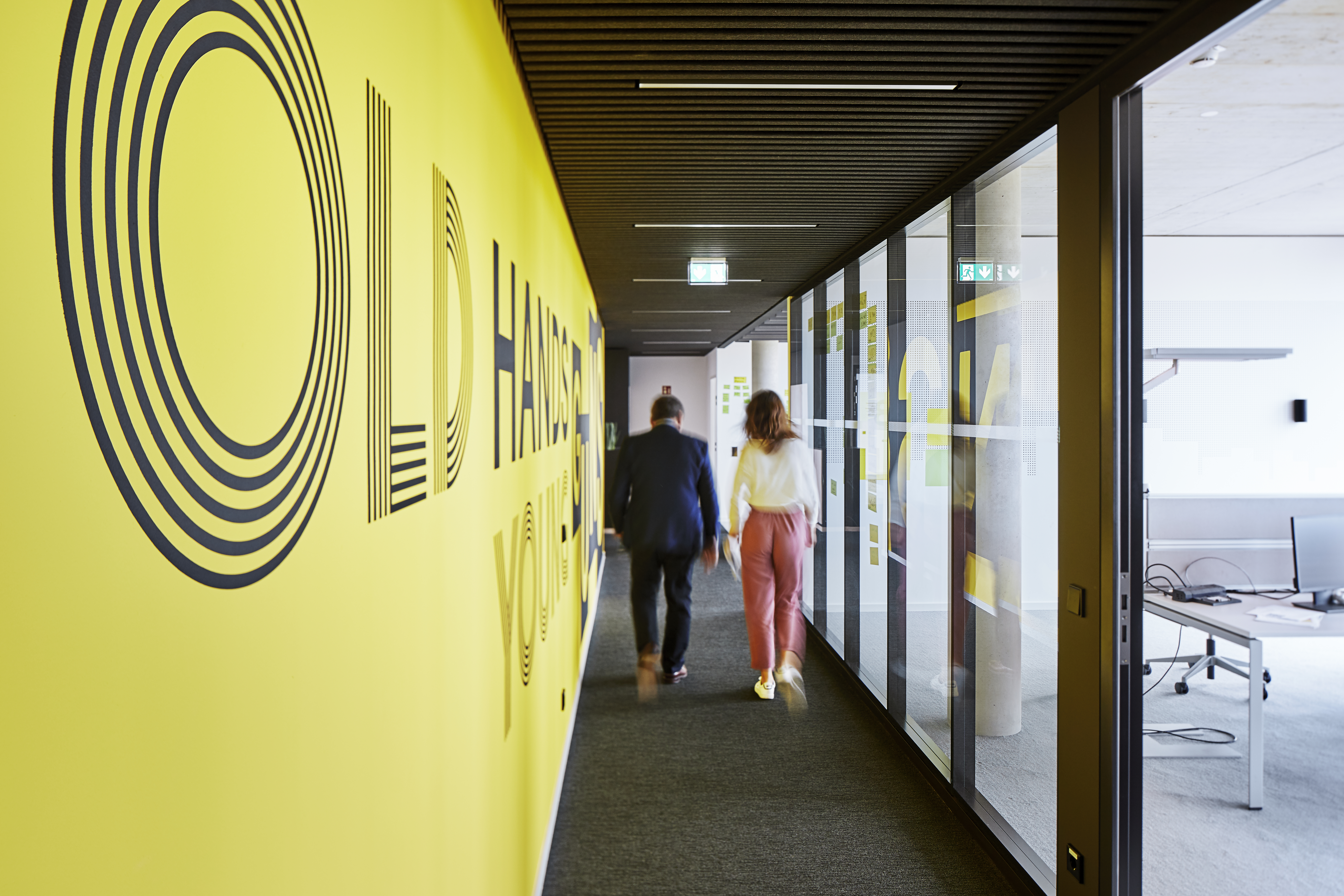 Menschen im Gang eines modernen Büros mit Start-Up-Flair
