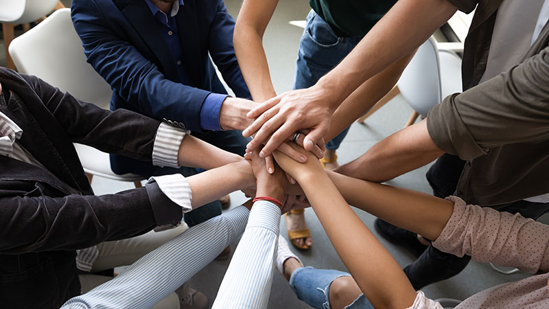 Nahaufnahme von Hand als Symbol für Teambildung, Loyalität, Freundschaft und warme Beziehungen