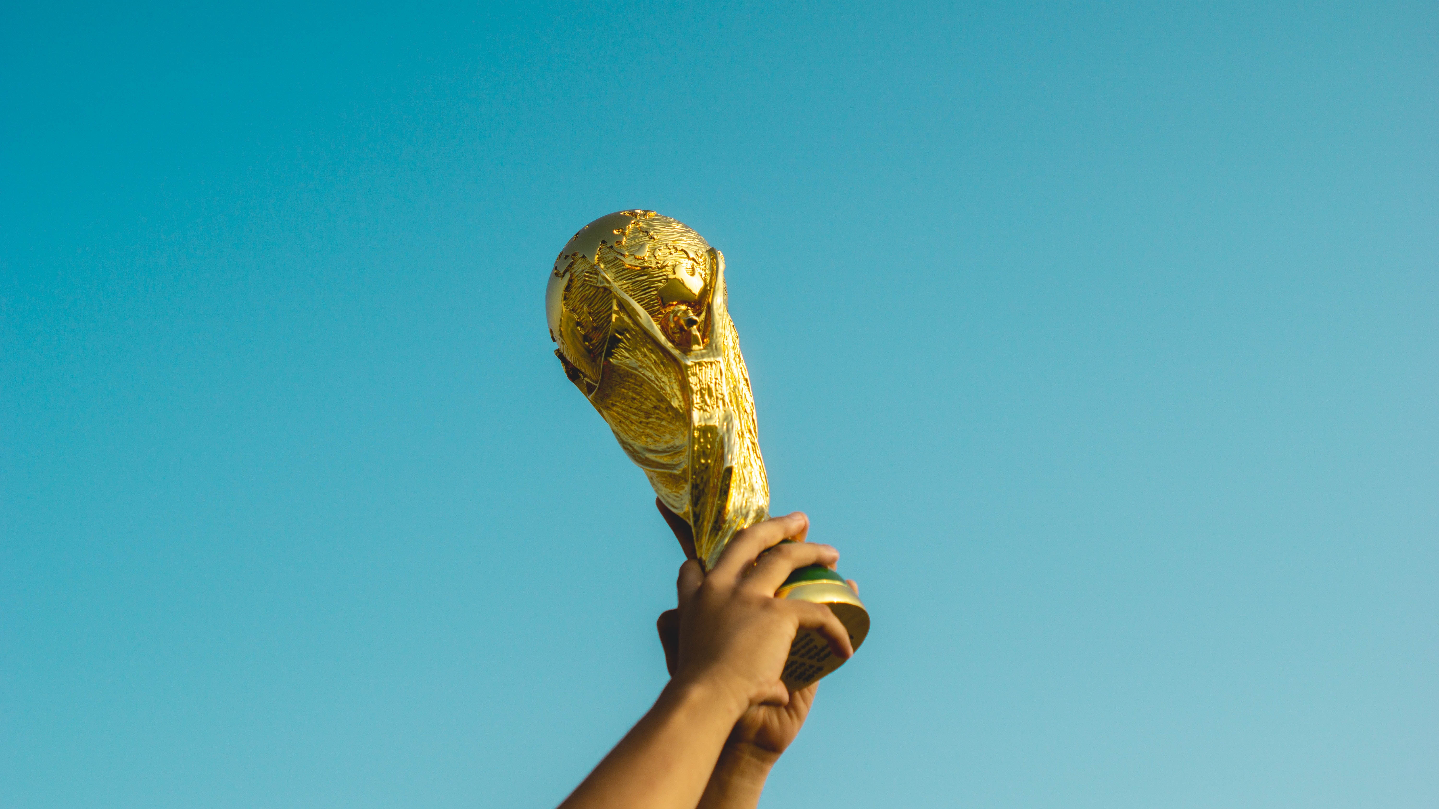 Hände, die Pokal in die Höhe recken