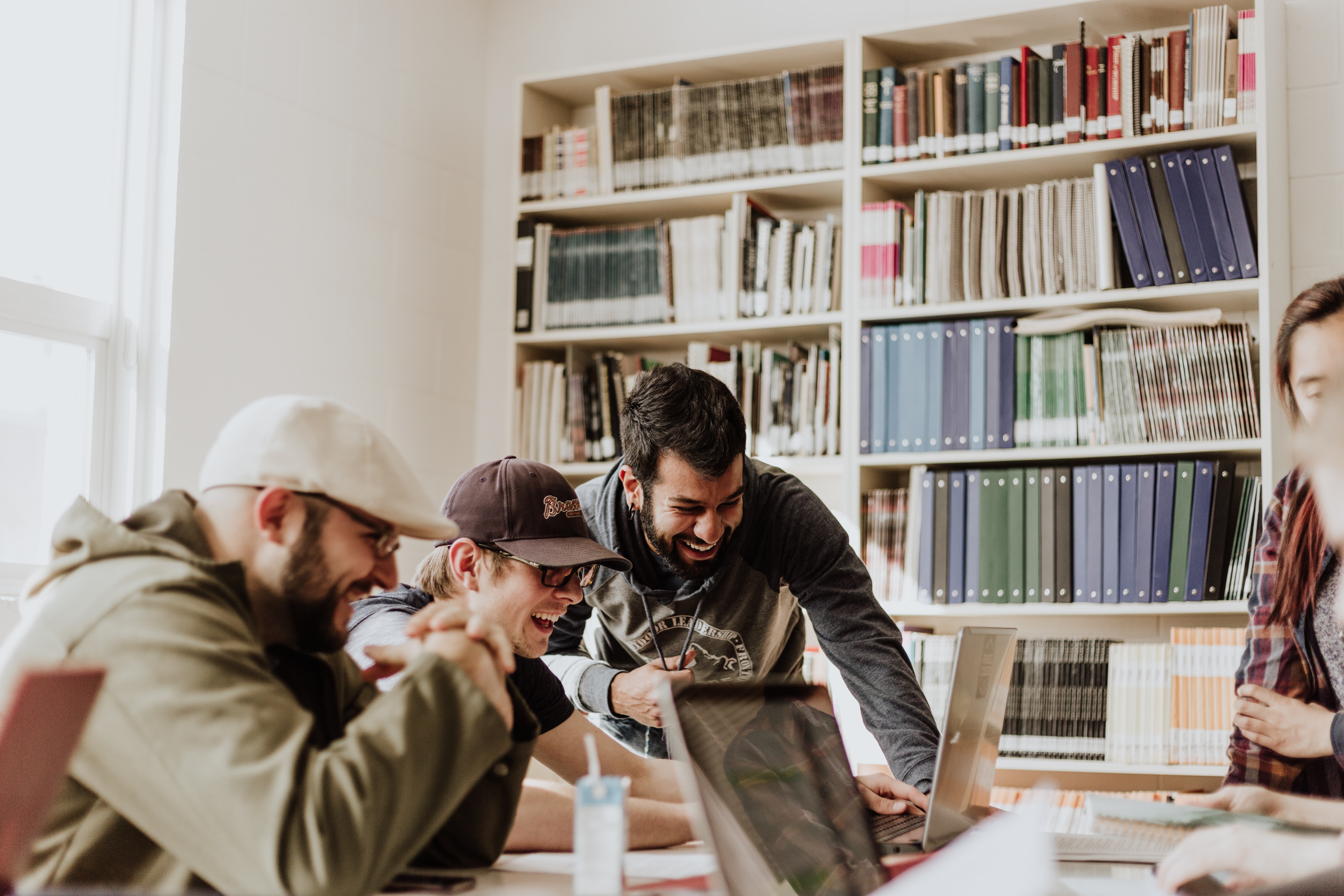 3 Personen lachend am Arbeitsplatz