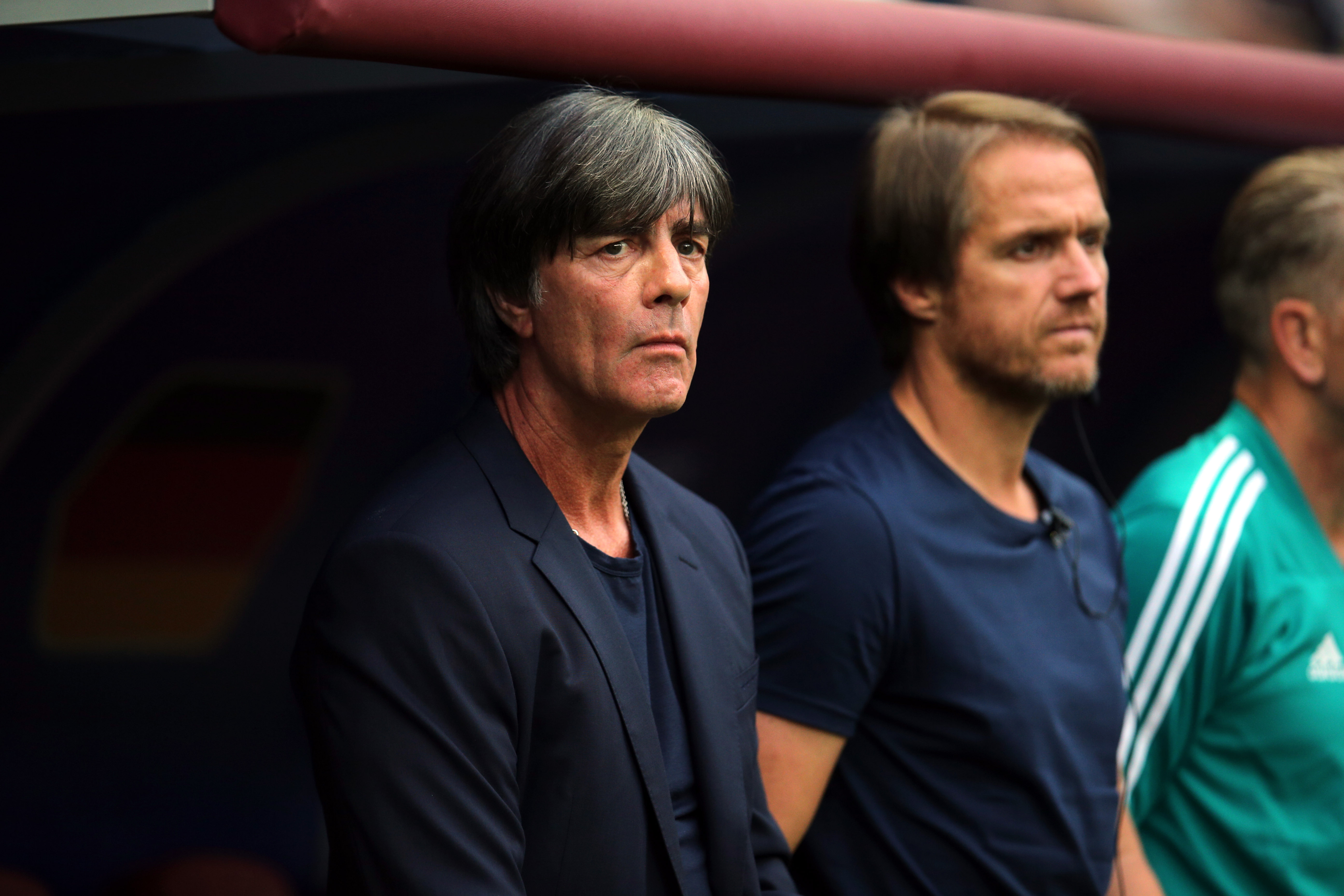 Foto von Jogi Löw und Co-Trainer stehend vor der Trainerbank auf Spiel schauend