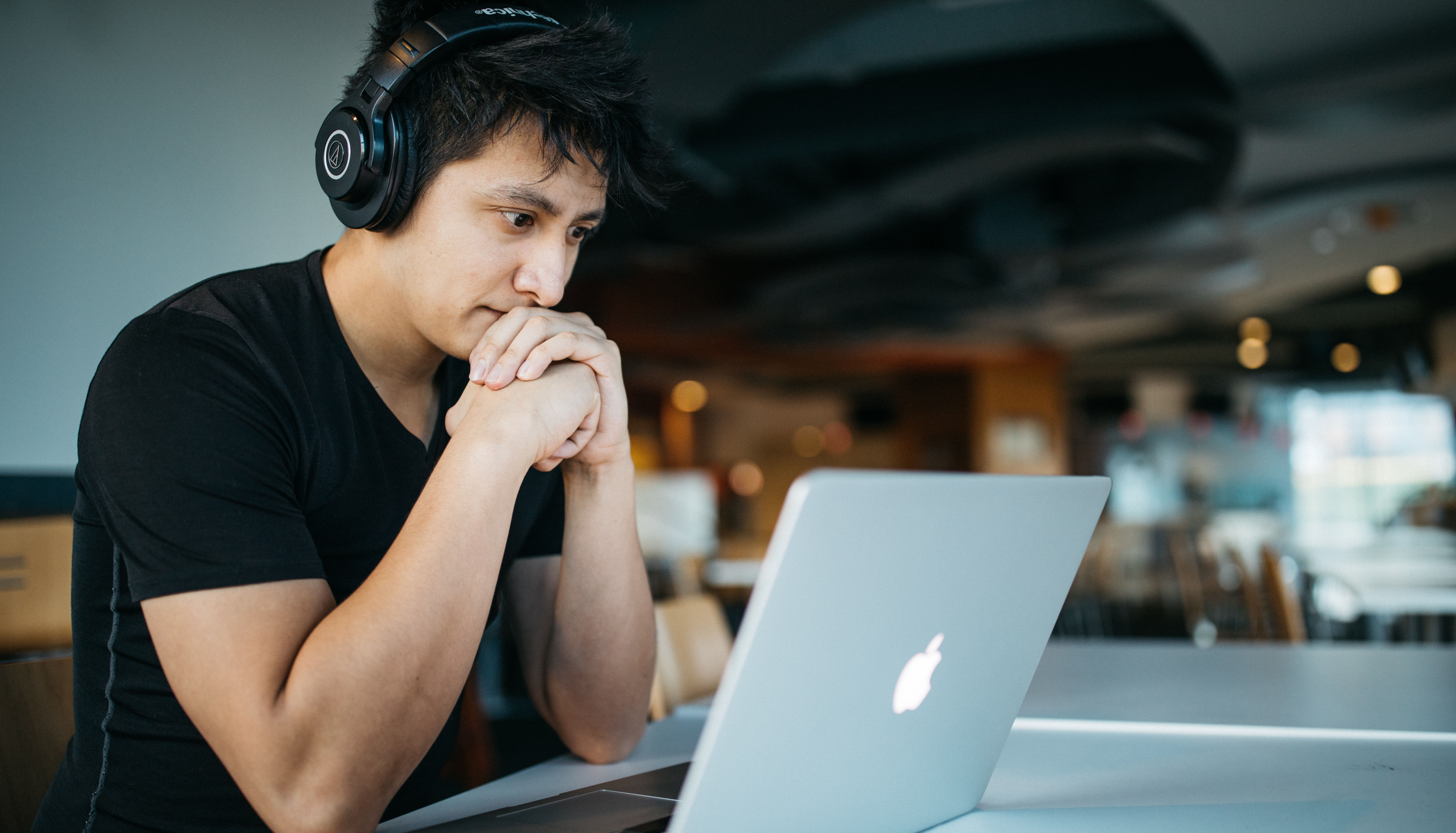 Konzentrierter, junger Mann am Laptop