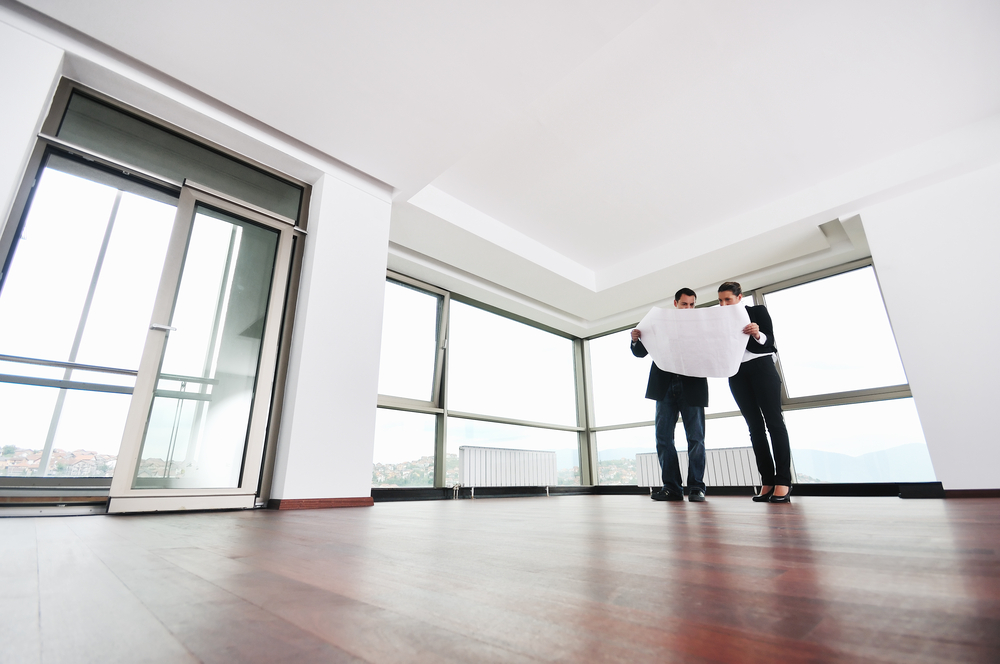 Zwei Männer schauen auf einen Plan in einem leeren Büro
